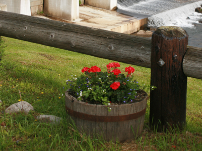 fence post with a basket of flowers sitting in the grass