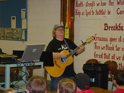 Teacher playing the guitar for her students