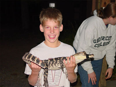 Male student holding a baby alligator