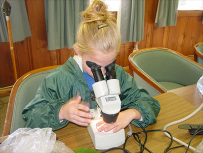 Female student looking into a microscope