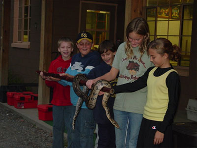 Five students holding a snake together